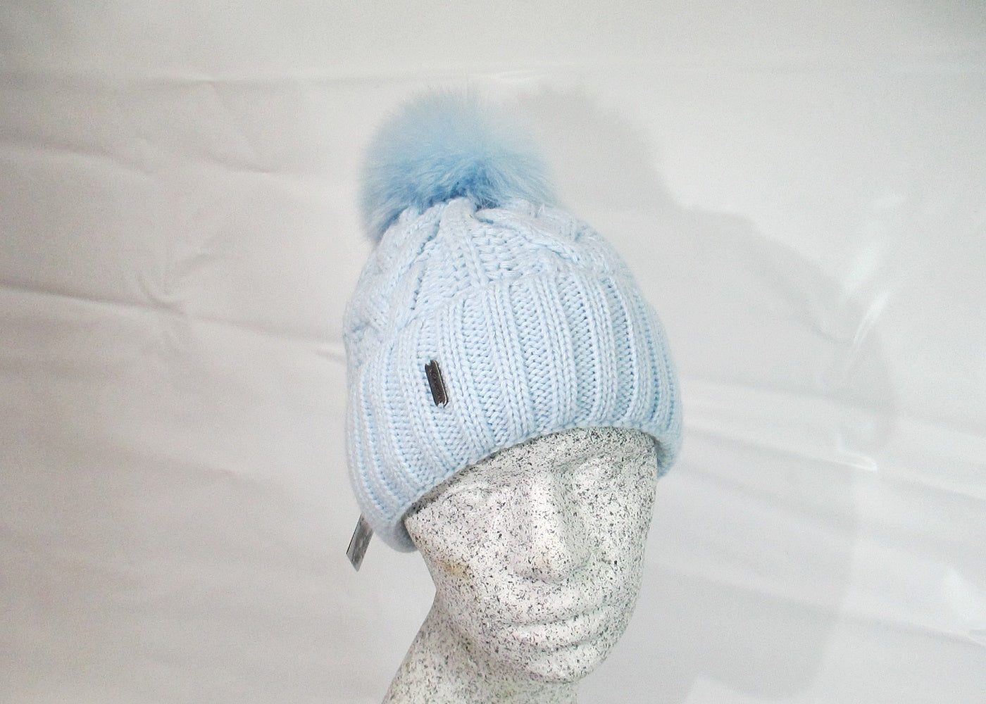 Braided cap with fox pompom
